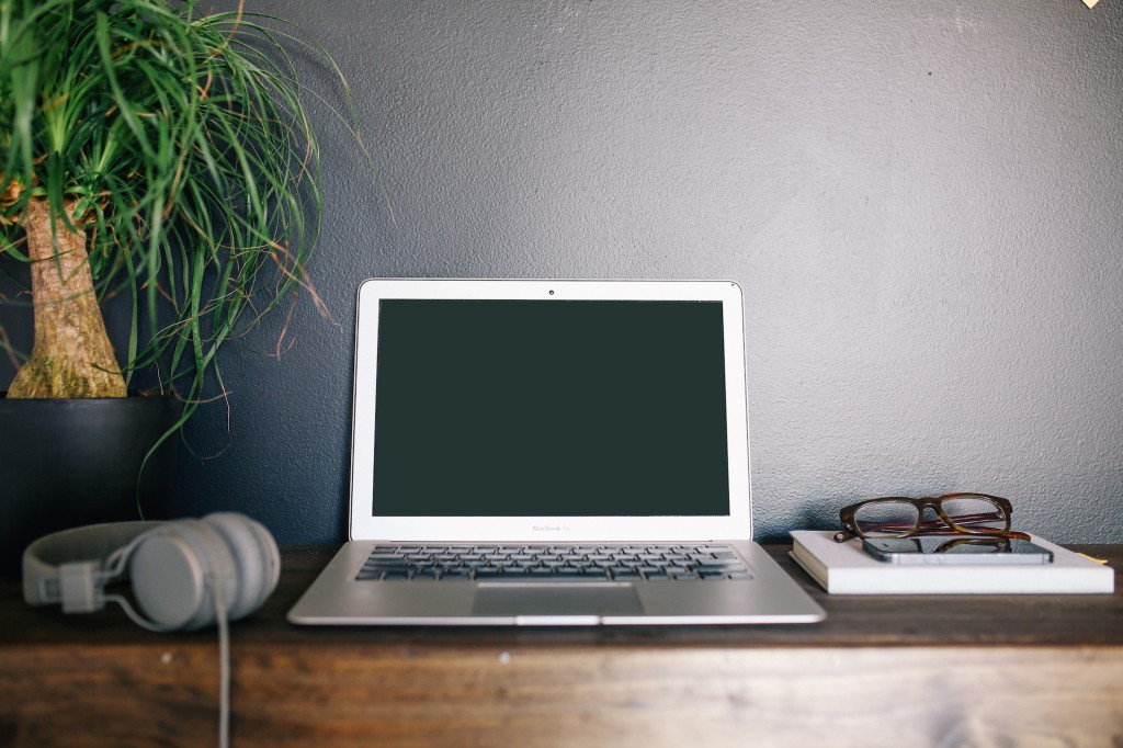 Open laptop on a sideboard with headphones